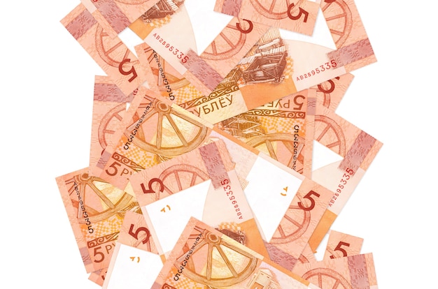 5 billetes de rublos bielorrusos volando hacia abajo aislado en blanco. Muchos billetes caen con espacio de copia en blanco en el lado izquierdo y derecho