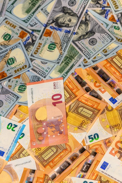 Foto 50-euro- und 100-dollar-scheine verstreut auf dem tisch als hintergrund 2