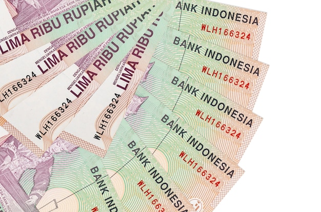 5000 billetes de rupia indonesia se encuentra aislado en la pared blanca con espacio de copia apilados en forma de abanico de cerca. Concepto de transacciones financieras