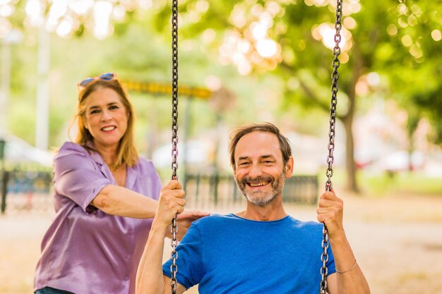 5059 años relación de felicidad senior familia hispana disfruta de la vida pareja con un columpio en un parque