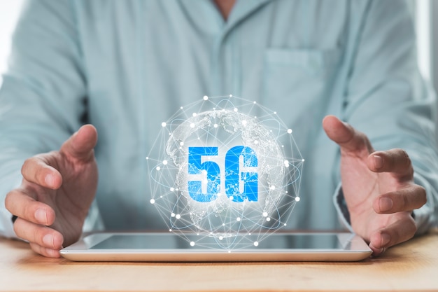 5G und Internet of Ding oder IOT-Konzept, Geschäftsmann schützt virtuelles 5G globales Netzwerk auf Tablet.