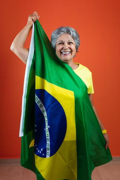 7 de setembro dia da independência do Brasil mulher madura com camisa amarela de cabelos grisalhos e bandeira isolada