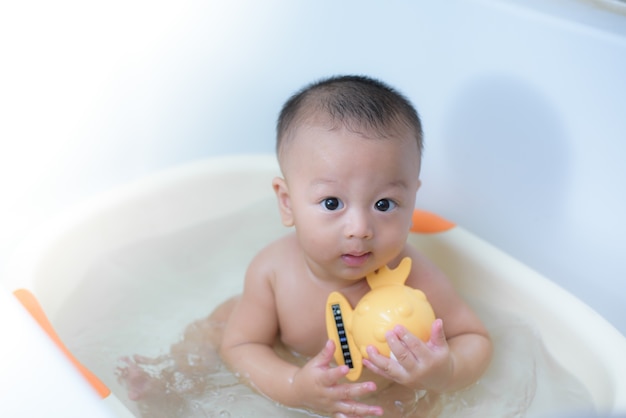 7 meses bonito menino tomando banho na sala de banho.