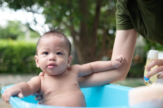 7 Monate altes Baby, das gut gelaunt im Freien badet