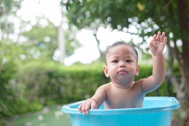 7 Monate altes Baby, das gut gelaunt im Freien badet