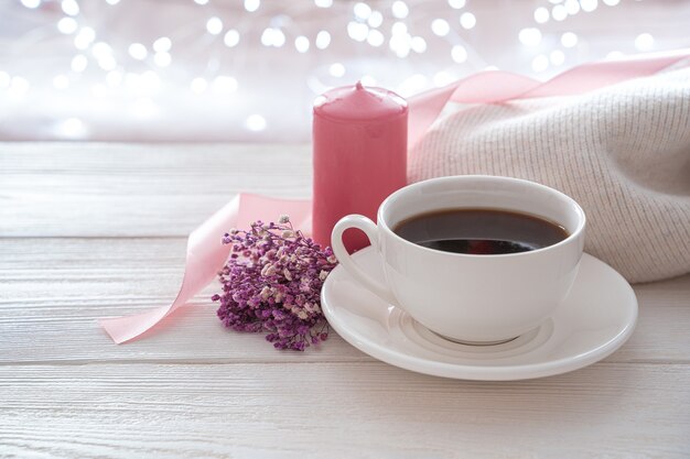 8 de março, café, um buquê e uma vela rosa sobre um fundo claro.