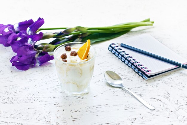 8 de março. dia da mulher. manhã. café da manhã. flores íris com um caderno e sobremesa cremosa