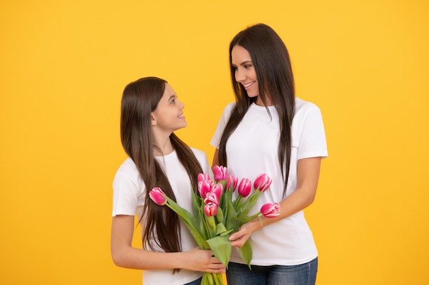 8 de março feliz mãe e filha com flores de tulipa em fundo amarelo