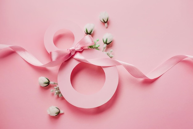 8 de março Papel número oito decorado com flores da primavera em um fundo rosa