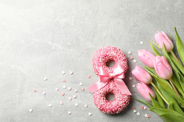 8 feitos de donuts e tulipas cor de rosa em cinza