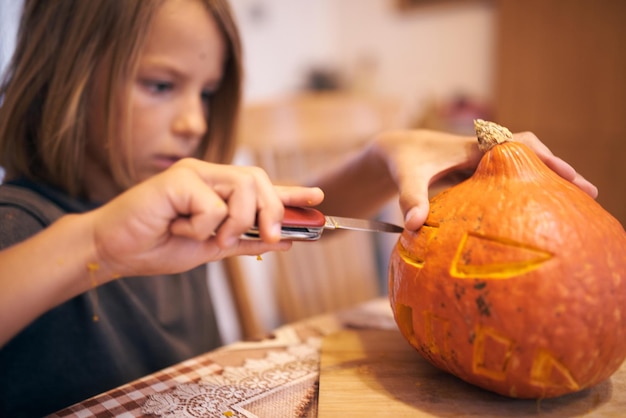 8-jähriger Junge, der Halloween-Kürbis schnitzt