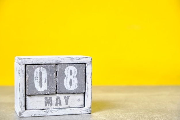 8. Mai Hölzerner Desktop-Kalender gelber HintergrundFrühlingsmonat auf Würfeln dargestelltPlatz für Ihre Ideen