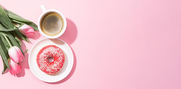 8 de marzo Día Internacional de la Mujer número ocho que consiste en una taza de café y un donut con un relleno rosa junto a tulipanes rosas en un espacio de fondo rosa para texto