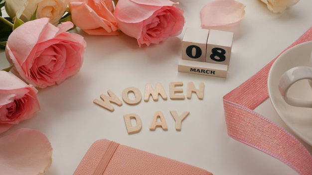 8 de marzo feliz día de la mujer sobre fondo blanco tabla decorado con flores rosas y cinta