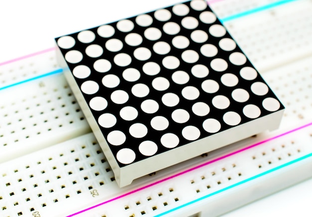 8x8 LED matriz arduino anexada a uma placa de ensaio em fundo branco. Conceito de um projeto técnico.