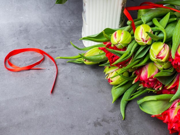 9. Mai Hintergrund Rote Tulpen und rotes Band auf dem konkreten Hintergrund freier Platz für Text