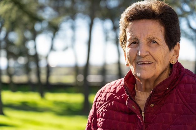 90 Jahre alte Seniorin lacht und schaut in die Kamera.