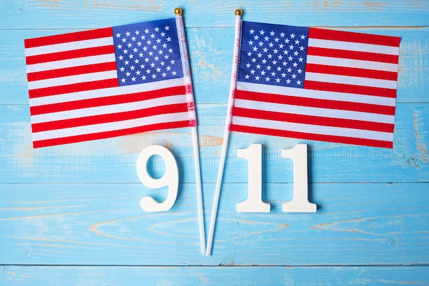 911 texto y la bandera de los Estados Unidos de América en el fondo de la mesa de madera. Día del Patriota, septiembre, memorial y concepto de Never Forget