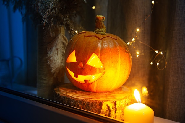 A abóbora esculpida olha pela janela. Jack Lantern, conceito de Halloween.