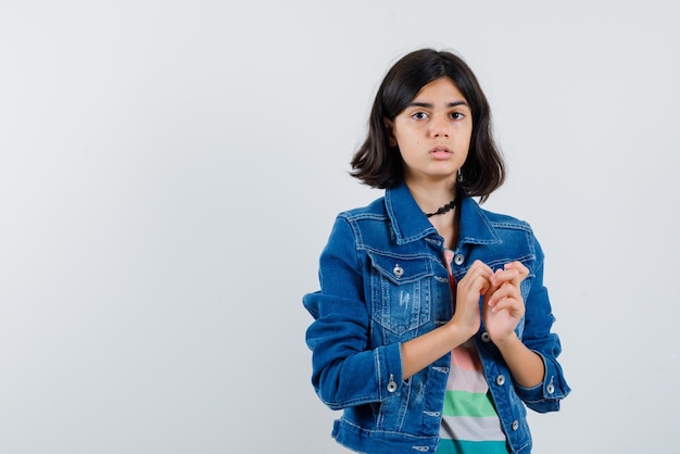 A adolescente está olhando para a câmera no fundo branco