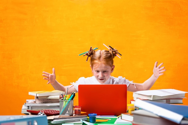 A adolescente ruiva com muitos livros em casa estúdio tiro