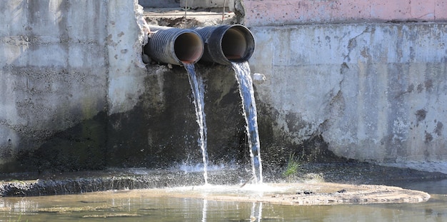 Foto a água suja flui de dois canos