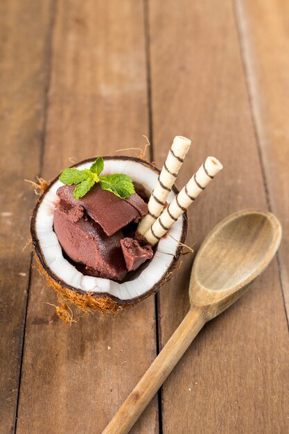 AÃ§ai brasileño sobre una cáscara de coco con un fondo de madera y frutas.