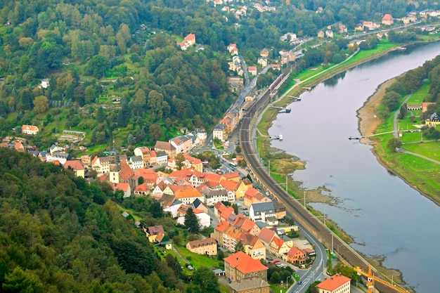 A aldeia com casas perto do rio e florestas verdes vista de cima