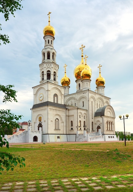 A alta torre do sino e as cúpulas douradas do templo no estilo arquitetônico russo. Khakassia, Sibéria, Rússia