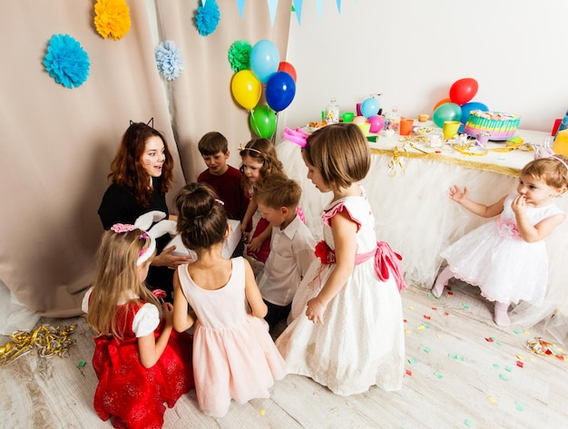 A animadora da mulher gato entretém as crianças dos convidados brincando na festa de aniversário