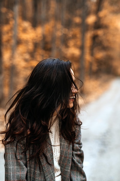 A ansiedade do outono, saúde mental, mulher morena feliz aproveita a vida na floresta do outono