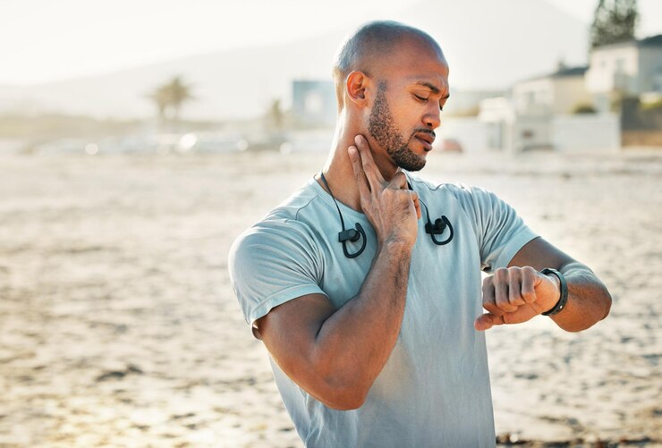 Foto a aptidão física é a base para a saúde foto de um homem usando seu relógio para rastrear seu pulso enquanto faz exercícios