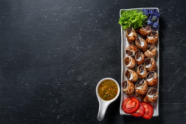 Foto a areola cozinhada, babylon manchado com marisco que mergulha o molho na tabela de madeira.