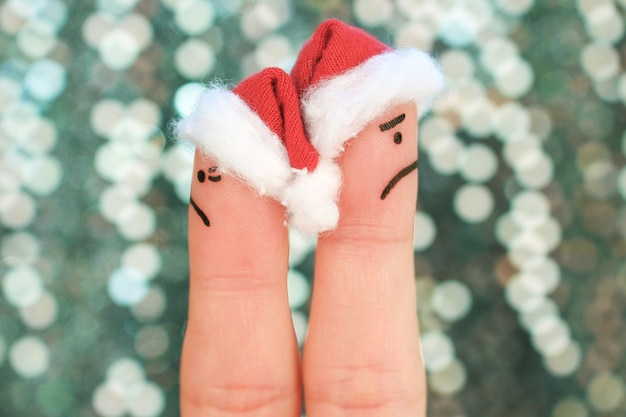 A arte dos dedos do casal celebra o Natal. Casal após uma discussão olhando em direções diferentes.