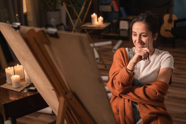 A artista está sentada em sua sala de estar e desenhando uma foto que a garota está satisfeita sorrindo enquanto ela