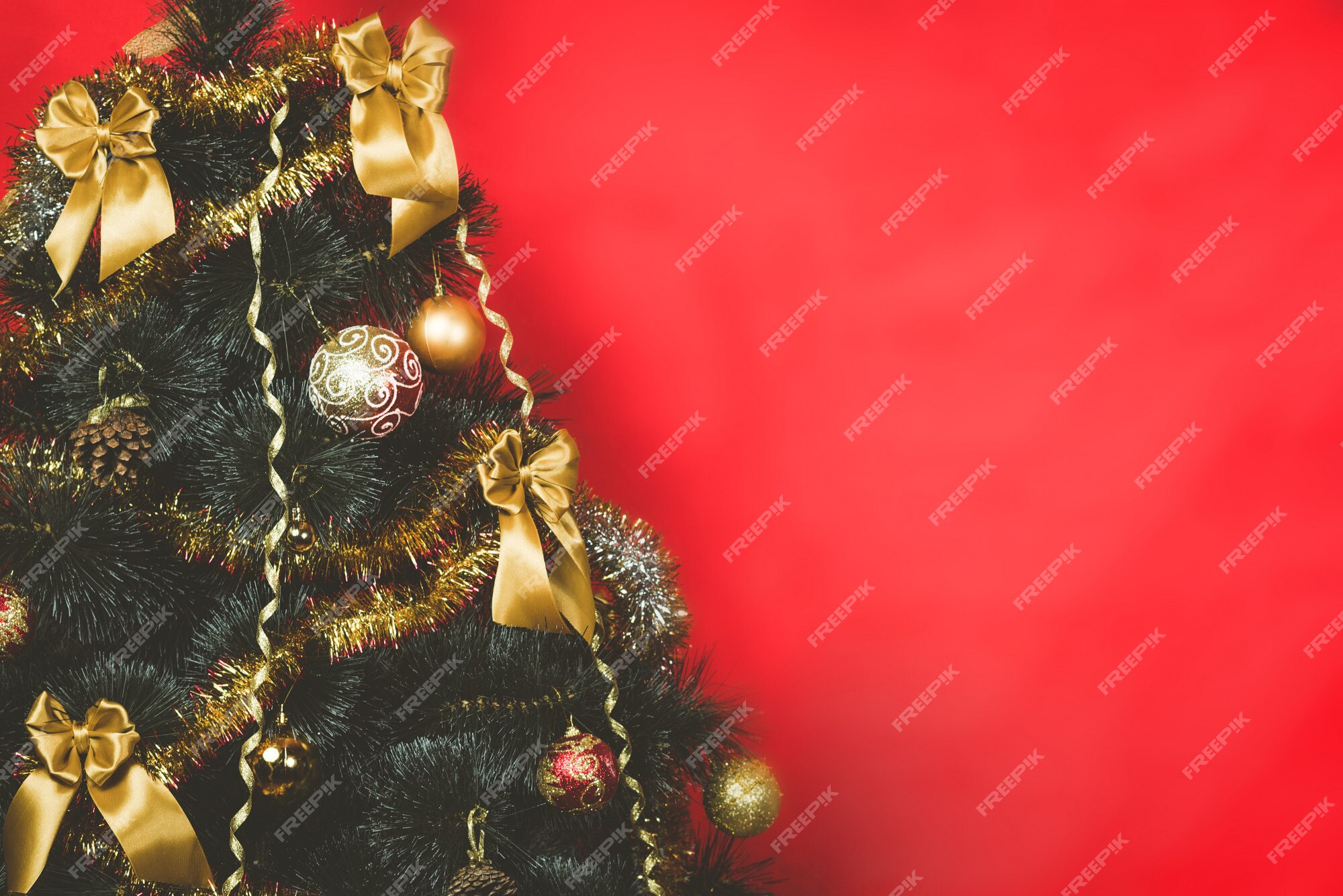 A árvore de natal decorada com fita do ouro curva-se no fundo vermelho com  espaço da cópia. | Foto Premium