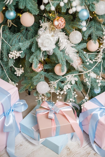 A árvore de Natal está decorada com brinquedos e guirlandas com presentes debaixo dela Presentes de Natal debaixo da árvore