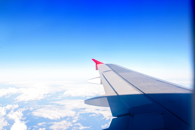 A asa do avião contra o céu. o conceito de viagens e vôos.