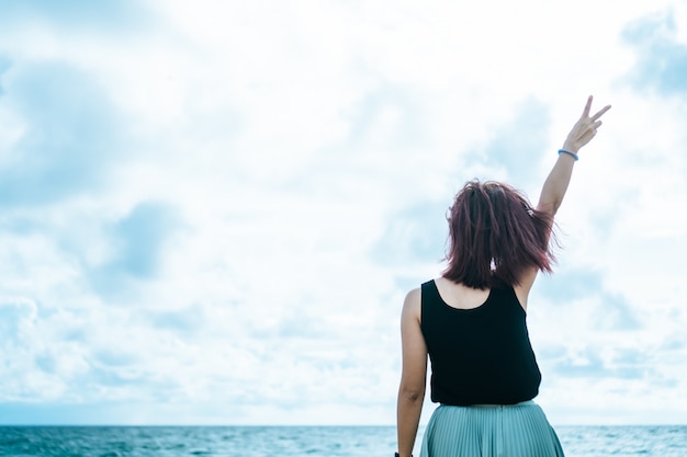 A ascensão da mulher entrega até o conceito da liberdade do céu com céu azul.