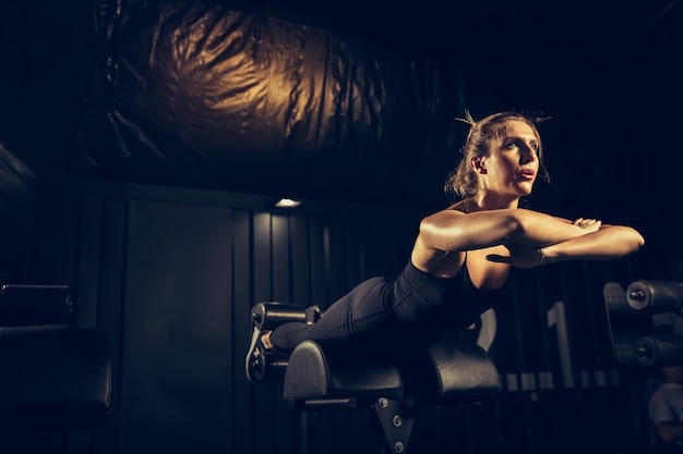 A atleta feminina treinando duro no ginásio. fitness e conceito de vida saudável.