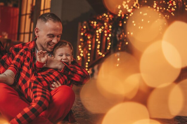 Foto a autêntica família feliz e fofa em pijama xadrez vermelho passa tempo juntos no lodge xmas decorado