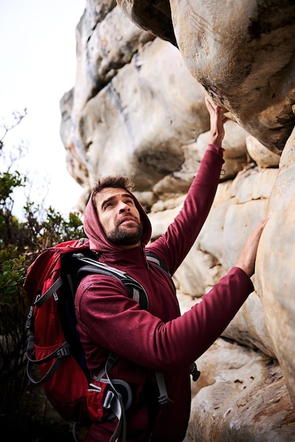 Foto a aventura de escalada em rocha e o homem na montanha natureza e ambiente para exercício ao ar livre atleta masculino ou esporte com atividade de treino para bem-estar fitness ou saúde com mochila para caminhadas