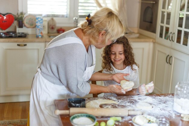 A avó amorosa alegre e a sobrinha dela estão preparando a padaria juntas, se divertindo na cozinha.