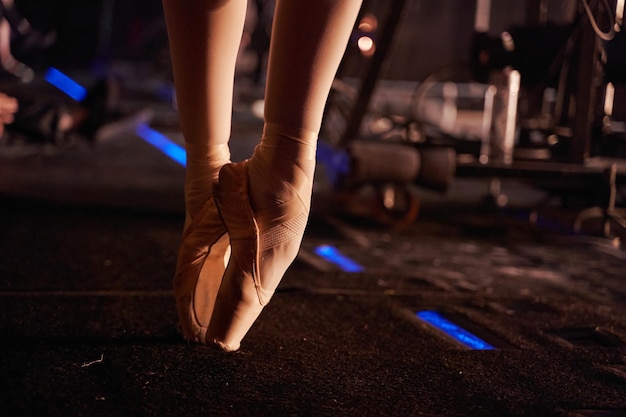 A bailarina fica na ponta dos pés em sapatilhas antes da performance