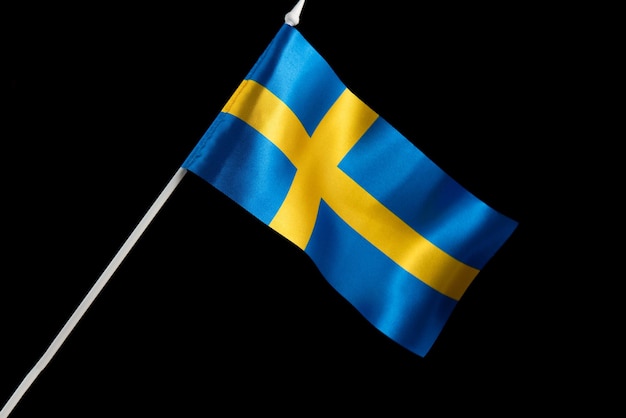 A bandeira da Suécia acenando a bandeira da Suécia em um fundo preto está se desenvolvendo e voando ao vento