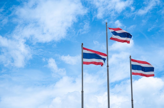 A bandeira da Tailândia em um poste alto com um céu brilhante e fundo de nuvens brancas