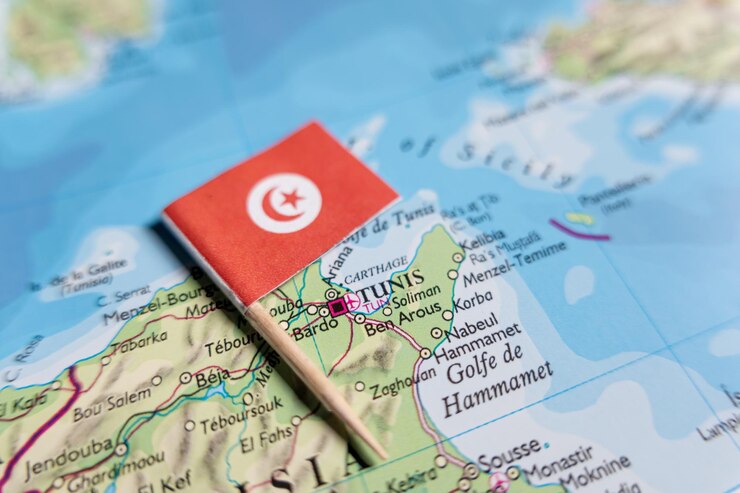 Foto a bandeira da tunísia está marcando a capital da cidade de tunis em um mapa do país africano tunísia