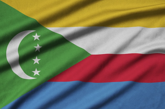 A bandeira das comores é retratada em um tecido esportivo com muitas dobras.