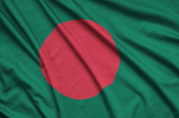 A bandeira de Bangladesh é retratada em um tecido esportivo com muitas dobras.