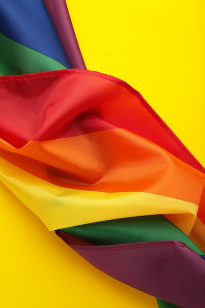 A bandeira do arco-íris LGBT em fundo amarelo Foto vertical